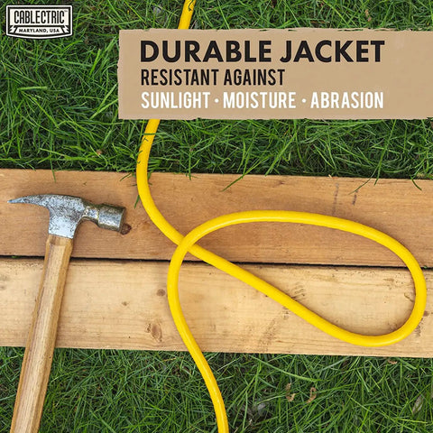 75 Ft Heavy Duty Outdoor Extension Cord 10 AWG Waterproof Yellow SJTW Power Cable on grass and wood with hammer nearby