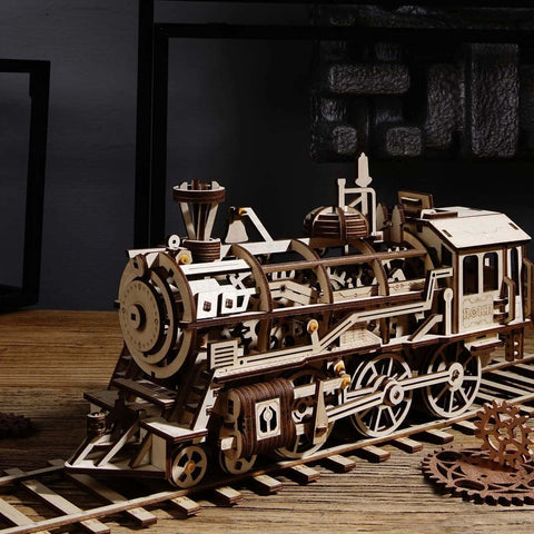 Wooden steam locomotive model kit made from unfinished basswood; natural wood finish with visible gears and wheels.