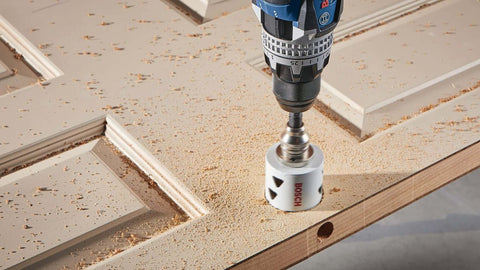 Close-up of Bosch HBT225 2-1/4 in bi-metal T-slot hole saw attached to drill cutting wood.