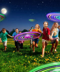 Children playing at night with LED Flying Saucer Toys 4 Pack With Built In Flashing Lights For Kids Outdoor Glow In The Dark Night Light Trails Party Favors Ages 4 8 12 Totally Lit For Group Games And Parties Outdoors Or Indoors.