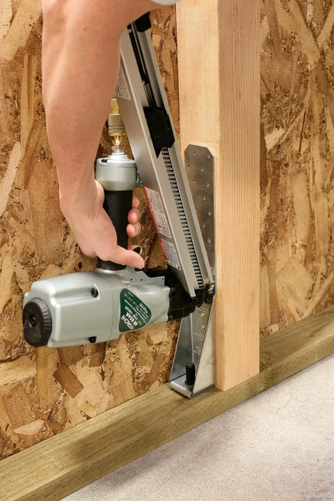 Person using nailer to attach metal connector with N10DHDGPT2500 Strong-Drive 33 SCN Smooth-Shank Connector Nail 2500 Count