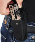 Person inserting 13 In 1 Outdoor Folding Multitool Pliers in Camo into a black nylon sheath on belt