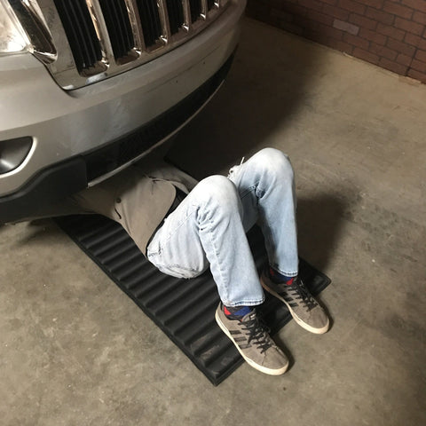 Person lying under a car on VersaMat Roll Up Workhorse High Density Foam Utility Mat Black For Garage And Home 1 Inch Thick Closed Cell Foam Heavy Duty Canvas Wrapped Portable 46 And Three Quarters By 25 Inch Roll Up Mat With Elastic Band