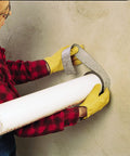 Person wrapping Graphite Based Intumescent Fire Barrier Wrap Strip 2 Inch By 40 Foot Flexible Firestop around pipe in wall.