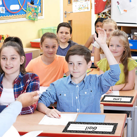 Students in classroom using 36 Piece Composition Desk Name Plates For Classroom 9.5 By 3 Inch Black And White Reusable Name Tags