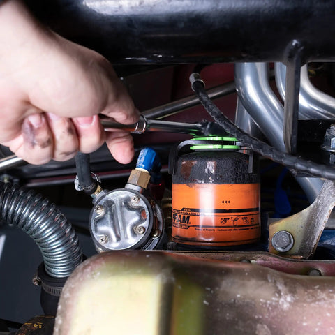 Hand using Beefy 3 Jaw Magnetic Oil Filter Wrench for Tight Spaces Heavy Duty Oil Filter Remover Fits 2.4 to 3.6 Inch Filters 3/8 Inch Drive Adjustable Auto Tool for DIYers and Pros to remove oil filter in engine bay