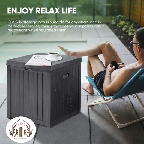 Man relaxing on patio with Rugged Outdoor Deck Box 51 Gallon Storage Chest For Patio And Porch nearby, holding drink