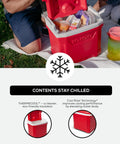 Picnic scene with Profile II 16 Quart Red Cooler With Fold Flat Bail Handle, Cool Riser Technology, open on grass.
