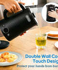 1.7L Large Electric Kettle With Temperature Control, 7 Cup Capacity, Black, being used to pour hot water into a glass.