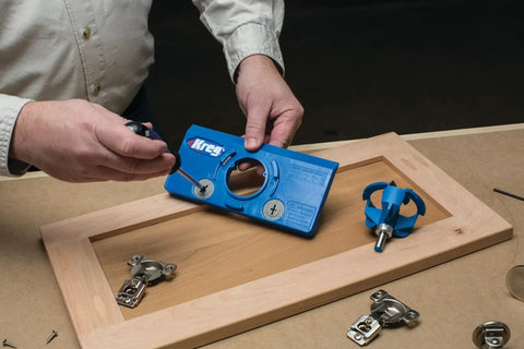 Person using Drawer Slide Jig And Concealed Hinge Jig Kit For Cabinets And Desks on a wooden cabinet door