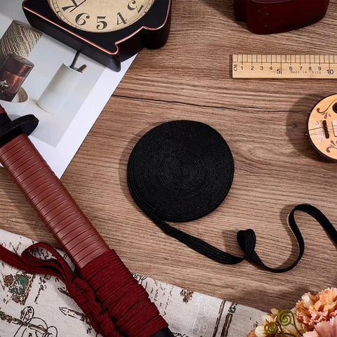 7M Black Ito Sageo Wrapping Cord 0.5 Inch Wide Silk Cotton Blend Rope for Katana Handle next to wrapped sword handle