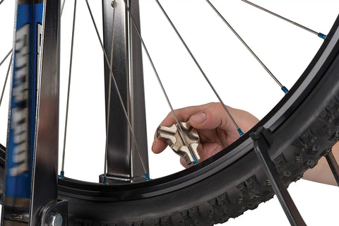 Triple Spoke Wrench For Bike Wheels, Heavy Duty Alloy Tool For Quick Wheel Truing shown in use on a bike wheel
