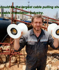 Construction worker holding Heavy Duty Cable Pulley Sheave For Large Scale Wiring Projects And Industrial Laying Built Tough With High Load Smooth Pulling Wire Pulling Sheave 7x8 Pulleys For Construction And Tunnel Installations.