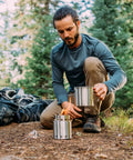 Camper setting up Ultra Lightweight Wood Burning Stove Kit For Backpacking And Camping With Backup Alcohol Burner Survival Ready