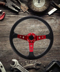 Universal 14 Inch Red PU Racing Steering Wheel With Horn Button Drift And Game Ready Grip For Cars Golf Carts Go Karts Off Road Vehicles Compatible With Simulators And Arcade Racing displayed on rustic wooden background with tools.