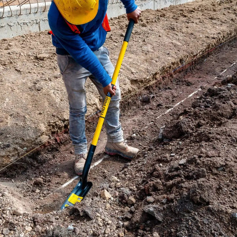 Worker using TruPro California Trenching Shovel With 4 Inch 13 Gauge Steel Blade in soil for pipe trenching