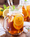 Generous 3 Quart White Stainless Steel Iced Tea And Cold Brew Coffee Brewing Pitcher With Adjustable Strength Dial and Removable Infuser Chamber, serving iced tea with lemon.