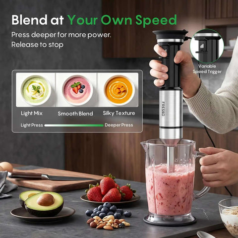 Total Game Changer Handheld Immersion Blender With Titanium Coated Blades And Variable Speed Trigger blending ingredients in a clear pitcher.