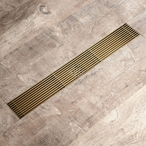 Straight Up The Best Slick Brushed Gold Linear Shower Drain With Badass 304 Stainless Steel Construction And Integrated Hair Catcher For Lightning Fast High Flow Drainage In Any Modern Home Setup Today on wooden floor.