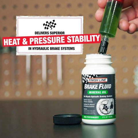 Person filling Bicycle Hydraulic Disc Brake Fluid Mineral Oil Low Viscosity For Crisp Lever Feel Smooth Pad Retraction And Consistent Stopping Power Long Lasting 16 Ounce Bottle