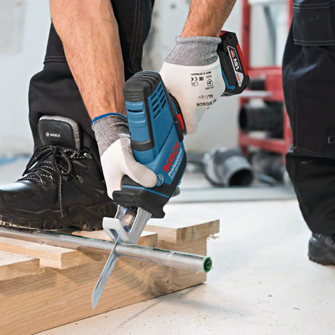 User operating Professional Grade Cordless Saber Saw on framing lumber and metal conduit for heavy duty renovations.