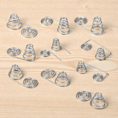 Dope 50 Pack Battery Spring Replacement Set For AA And AAA Coils shown with various nickel plated steel springs on wood surface