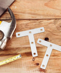 Beefy Heavy Duty Stainless Steel Corner Bracket Plates next to hammer on wood surface, ideal for shelving and panels, T shaped angle braces