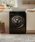 Modern washing machine in a cozy laundry room with plants and shelves above, showcasing a woven basket and wooden flooring.