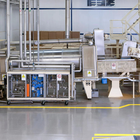 Industrial equipment with pipes and machinery in a factory setting.