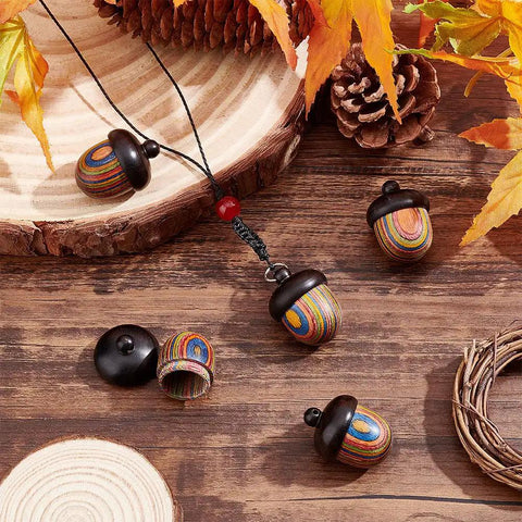 Five Pack Rainbow Wood Acorn Pendant Set With Openable Mini Cremation Urns For Ashes on wooden table