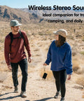 Couple hiking with Compact Waterproof Portable Bluetooth Speaker That Goes Hard With Deep Bass, Dual Pairing, FM Radio, USB And AUX Input, 24 Hour Playtime, Great For Home Patio And Outdoor Adventures.
