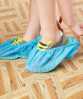 Person wearing Disposable Shoe Covers X Large 100 Pack Of 50 Pairs Non Slip Floor Protection For Shoes Up To Mens 14 Universal Fit