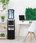No Fuss Three In One Hot And Cold Water Cooler Dispenser Featuring Built In Bullet Ice Maker And Simple Top Load Five Gallon Bottle Compact Black Finish in office setting.