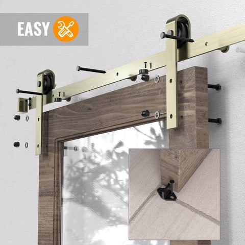 13 Foot Classic Brass Sliding Barn Door Hardware Kit for Interior Double Doors with Brushed Gold Finish installed on wooden door