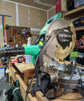 Vacuum Dust Adapter For Metabo HPT And Hitachi Miter And Chop Saws Two And A Half Inch Green Dust Collection Attachment installed on saw