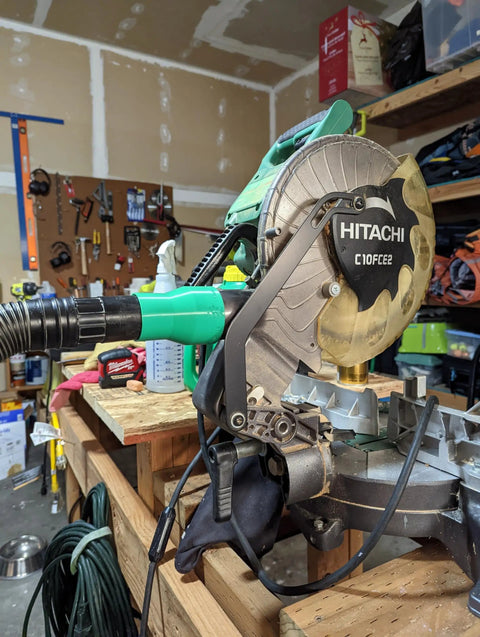 Vacuum Dust Adapter For Metabo HPT And Hitachi Miter And Chop Saws Two And A Half Inch Green Dust Collection Attachment installed on saw