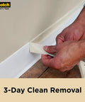 Person using Go To Contractor Grade Tan Masking Tape For General Use And Multi Surface Projects, 1.41in wide by 60.1yd roll, on baseboard.