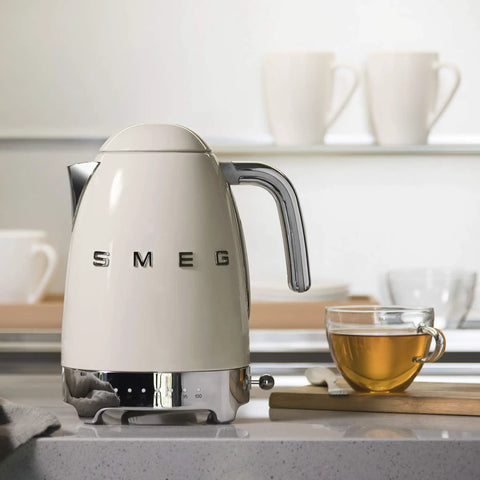 Variable Temperature Electric Kettle 1.7L With Fast Boil 1400W For Tea Or Coffee Nerds 122F To 212F Adjustable Temperature Keeps Warm Auto Shut Off 360 Degree Swivel Base Retro Cream Finish on countertop with teacup