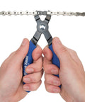 Hands using Master Link Pliers MLP 1.2 for bicycle chains with master links, easy install and removal tool, demonstrating use on chain.
