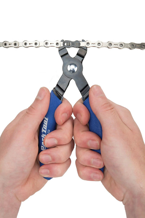 Hands using Master Link Pliers MLP 1.2 for bicycle chains with master links, easy install and removal tool, demonstrating use on chain.