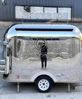 Built Different Stainless Steel Food Truck With Fully Loaded Commercial Kitchen Sleek Custom Mobile Concession Trailer from the side view.