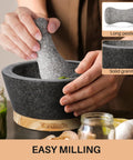 Person using 6 Inch Granite Mortar And Pestle Set With Anti Scratch Wood Base, Heavy Duty Grinder For Spices And Herbs