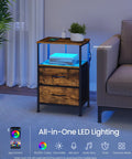Solid Industrial Nightstand With Fast Charge Hub And Smart Led Dimmer Two Deep Drawers Plus Open Shelf Rustic Brown Black Frame next to a sofa.