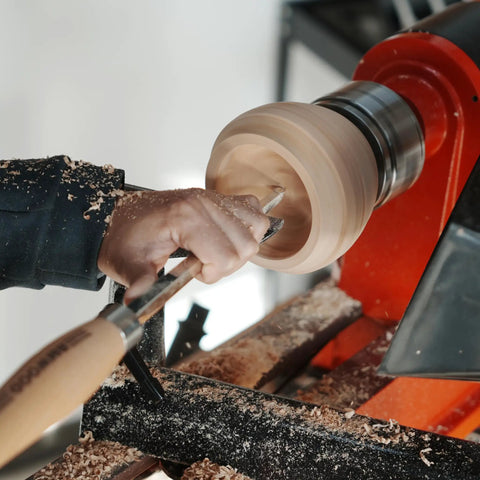 Heavy Duty Woodturning Hollowing Tool With Replaceable Carbide Tipped Round Blade And Solid Beech Handle in use shaping a wooden bowl on a lathe.