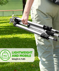 Person carrying Tripod Base Brass Impact Sprinkler With Pulsating 360 Degree Coverage, folded for easy portability in a park setting.