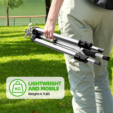 Person carrying Tripod Base Brass Impact Sprinkler With Pulsating 360 Degree Coverage, folded for easy portability in a park setting.