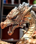 Close-up of a metallic steampunk dragon head on a wine bottle holder, part of a Steampunk Dragon Wine Bottle Holder With Two Glasses Metal Gothic Wine Rack For Home Bar Man Cave Decor Gift For Men 11 Point 6 Inch High Holds One Bottle And Two Glasses.