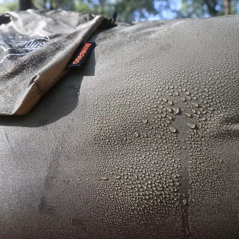 Close-up of water droplets on Cozy Hammock Underquilt Protector Water Resistant Cover, showing breathable 1.1 oz nylon ripstop material.
