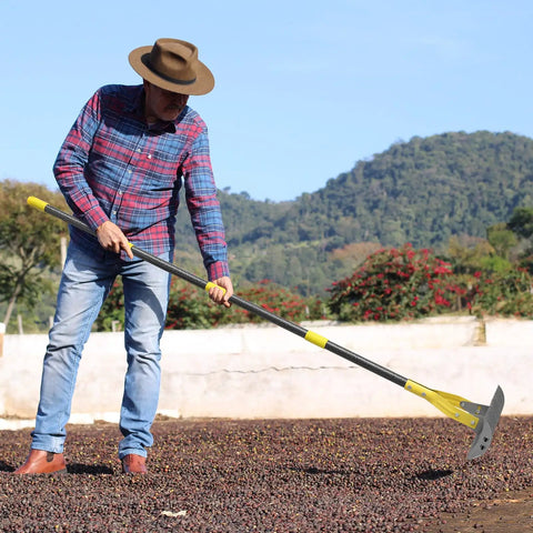 Man using 19 Tine Cold Pressed Steel Dethatcher Rake With 72 Inch Adjustable Handle And Ergonomic Grip for lawn care.