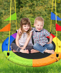 Two children sitting on Heavy Duty 750Lb Saucer Tree Swing With Adjustable Straps, colorful design, in outdoor backyard setting.
